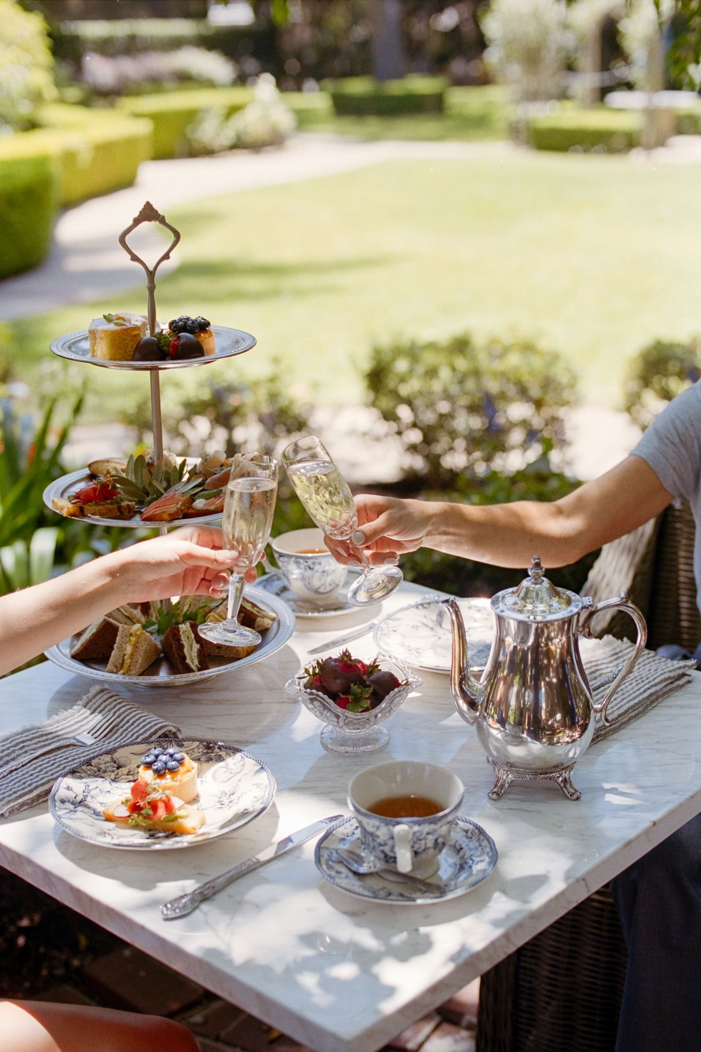 Afternoon tea in the gardens of the Simpson House Inn: tiered trays, sparkling wine, and a silver tea service