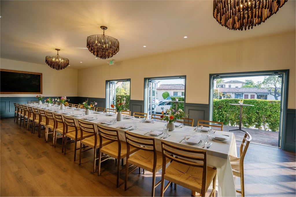 The Drawing Room with its French doors open to the garden, chandeliers overhead