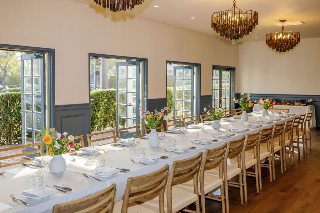 The Drawing Room set for an event beneath three chandeliers, with French doors open to the garden